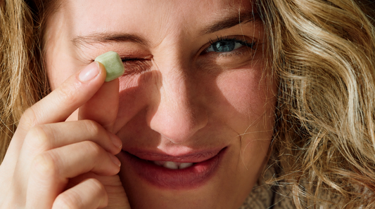 Smiling woman holding a piece of green chewing gum