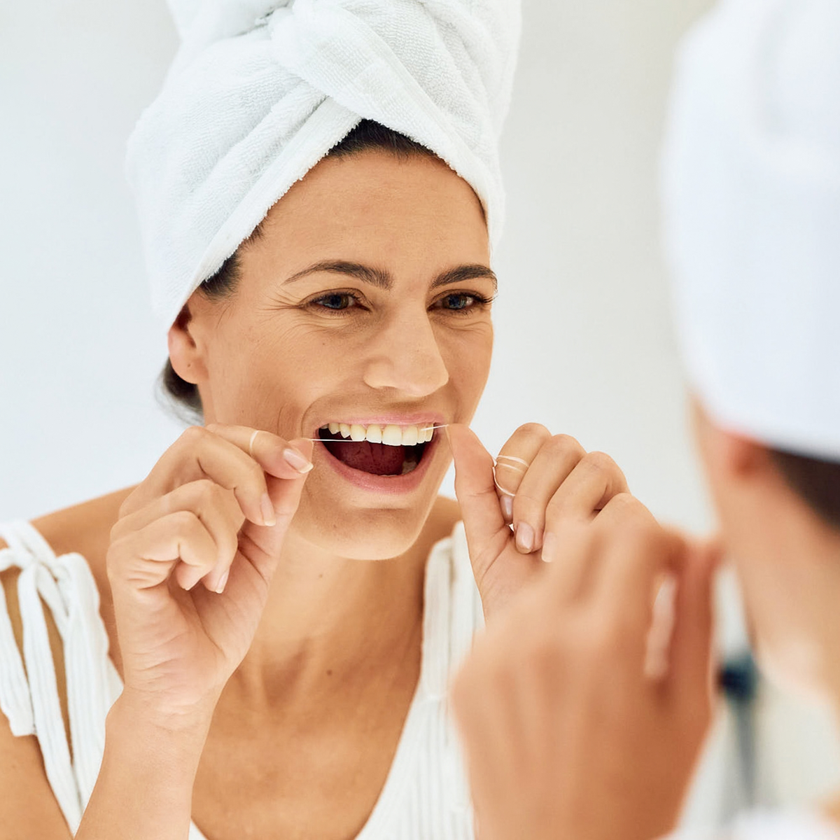 Woman flossing her teeth with ApaCare Mineral Floss