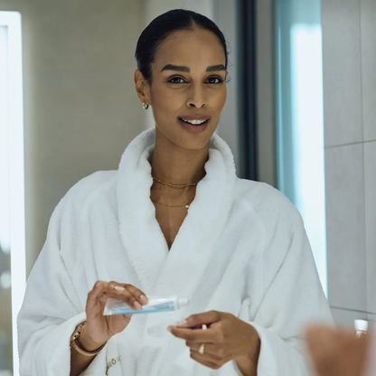 Woman in a bathrobe preparing ApaCare Repair paste and dental splint